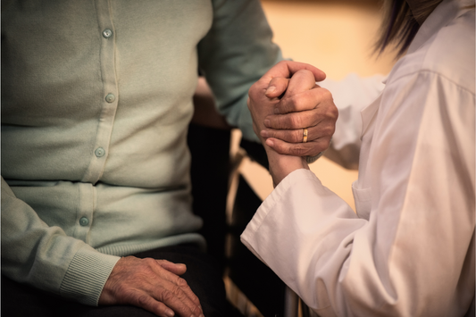An older person holding the hands of a younger person