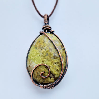 A close up of a Green Opal wire wrapped pendant - for emotional healing.