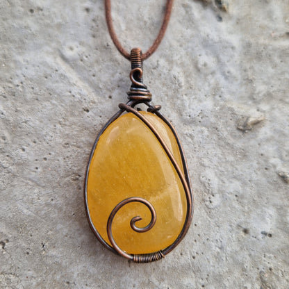 Oval imprinted orange calcite healing crystal pendant